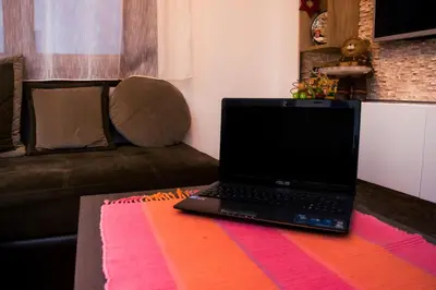 a laptop computer sitting on a table in a living room at Apartment Aleksija in Niš