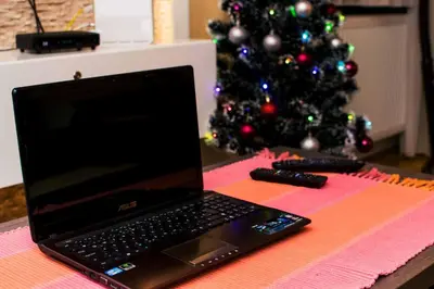 a laptop computer sitting on a table next to a christmas tree at Apartment Aleksija in Niš