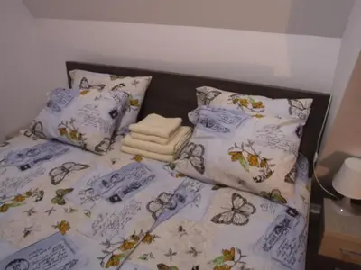 a bed with blue and white sheets and pillows at Apartments Mitic in Kopaonik