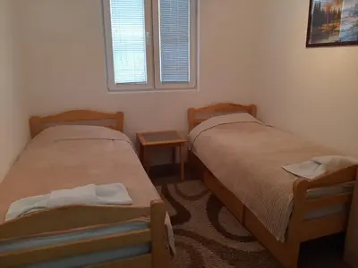 two twin beds in a room with a window at Vikendica RTANJ in Rtanj
