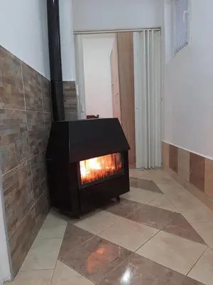 a fireplace in a room with a tile floor at Vikendica RTANJ in Rtanj