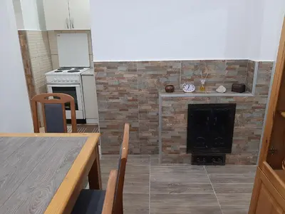 a kitchen with a fireplace with a stove and a table at Vikendica RTANJ in Rtanj