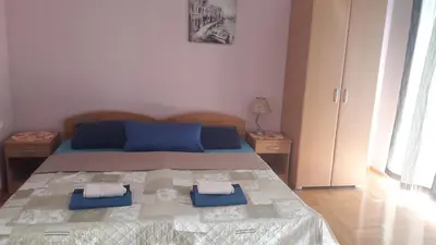 a bedroom with a bed with blue pillows on it at Apartmani V&F in Vrnjačka Banja