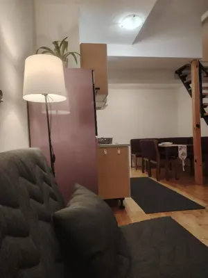 a living room with a couch and a lamp and a table at Studio Apartman Lenka in Soko Banja