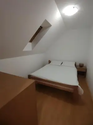 a small bedroom with a bed in a loft at Studio Apartman Lenka in Soko Banja