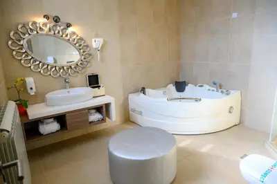 a bathroom with a tub and a toilet and a sink at Hotel Tami Residence in Niš