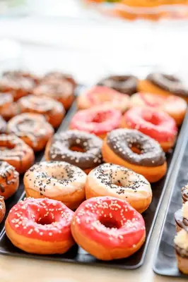 a tray of different types of donuts on a table at Hotel Tami Residence in Niš