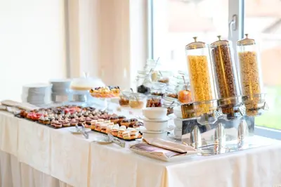 a buffet of food on a white table at Hotel Tami Residence in Niš