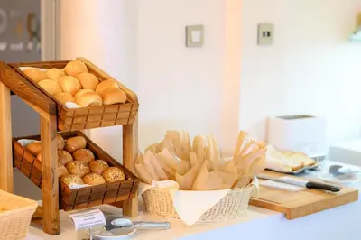 a counter with baskets of bread and baskets of pastries at Hotel Tami Residence in Niš