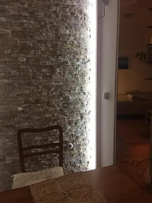 a chair in a room with a brick wall at Apartment Boris in Niš