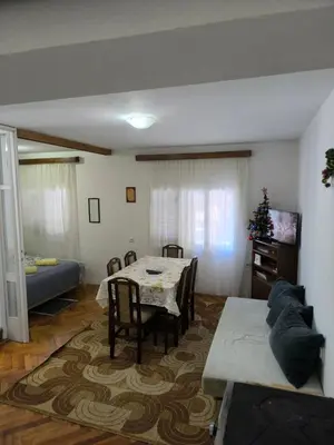 a living room with a table and a couch at Planinska kuća Vladanka - planina Goč - banjska strana - preko puta ski staze in Biserske Kuće