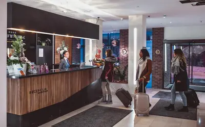 a group of people standing at a bar with luggage at Hotel Putnik Kopaonik in Kopaonik
