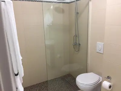 a bathroom with a toilet and a glass shower at B&B Alex18 in Niš
