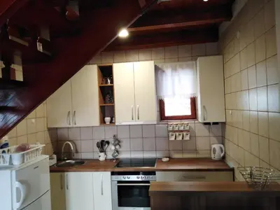 a kitchen with white cabinets and a stove top oven at Apartments Holiday Home Srce in Kopaonik