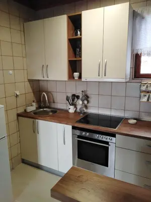 a kitchen with white cabinets and a sink and a stove at Apartments Holiday Home Srce in Kopaonik