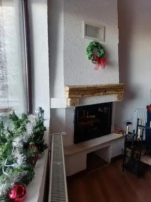 a living room with a fireplace with a christmas wreath at Apartments Holiday Home Srce in Kopaonik