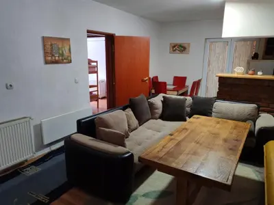 a living room with a couch and a wooden table at Kuca za odmor ''Djurovic'' in Kopaonik