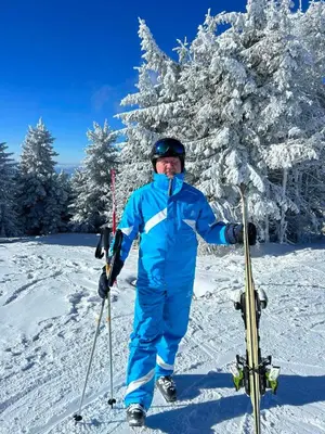 a man is standing in the snow with skis at Kuca za odmor ''Djurovic'' in Kopaonik
