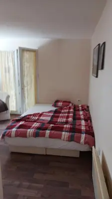 a bedroom with a bed with a plaid blanket at Kuca za odmor ''Djurovic'' in Kopaonik