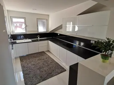 a kitchen with white cabinets and a sink and a potted plant at Atina Lux Hostel in Leskovac