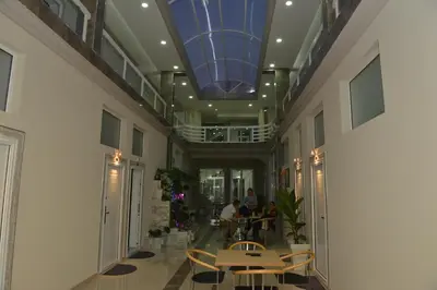 a hallway with people sitting at tables in a building at Atina Lux Hostel in Leskovac