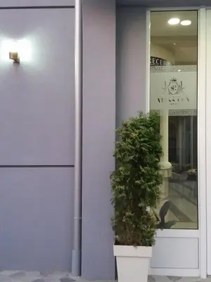 a plant in a pot in front of a building at Atina Lux Hostel in Leskovac