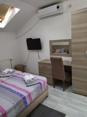 a bedroom with a bed and a desk with a computer at Atina Lux Hostel in Leskovac