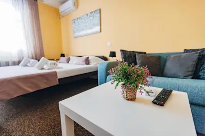a living room with two beds and a couch at Laguna Green Guest House in Niš