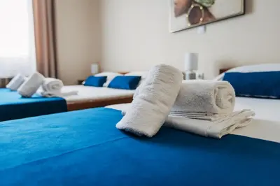 a room with two beds with towels on the bed at Laguna Green Guest House in Niš