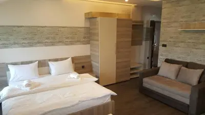 a bedroom with a large bed and a chair at K23 apartment Milmari in Kopaonik