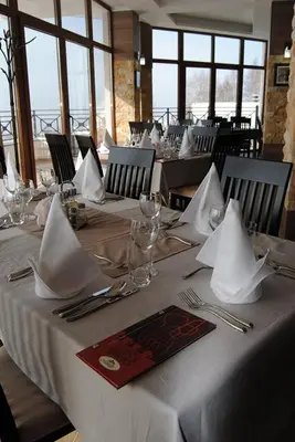 a table with white napkins and silverware at a restaurant at K23 apartment Milmari in Kopaonik