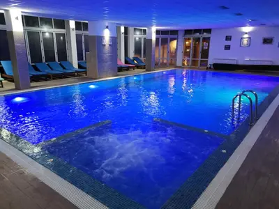 a large swimming pool with blue water in a hotel at K22 Apartment Milmari in Kopaonik