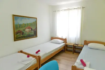 a room with two beds and a painting on the wall at Rooms Ela Ela in Prekodolce