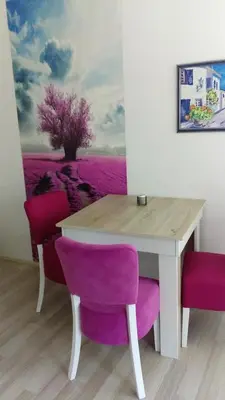 a table with purple chairs and a painting of a tree at Rooms Ela Ela in Prekodolce