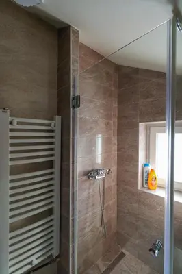 a bathroom with a shower with a glass door at Studio Apartments Maksimović in Niš