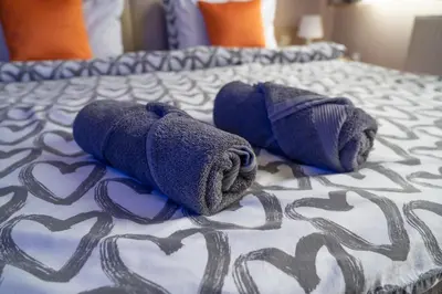 a pair of stuffed animals laying on a bed at Studio Apartments Maksimović in Niš
