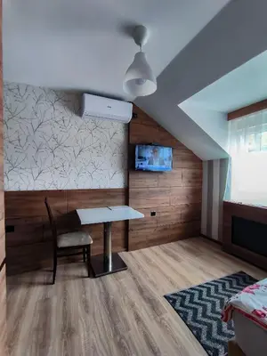 a dining room with a table and a bed at Studio Apartments Maksimović in Niš