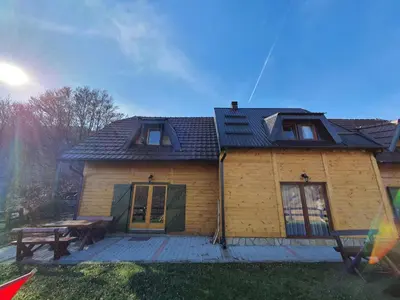 a wooden house with a picnic table on a deck at Vikendica Vila Despotovic in Kopaonik