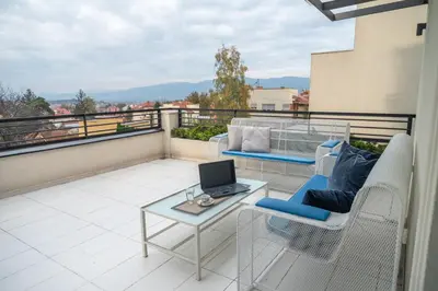 a balcony with a table and a laptop on it at Vila Opera in Vrnjačka Banja