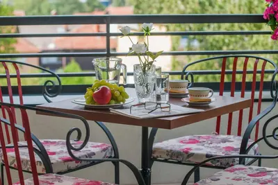 a table with a plate of fruit on a balcony at Vila Opera in Vrnjačka Banja