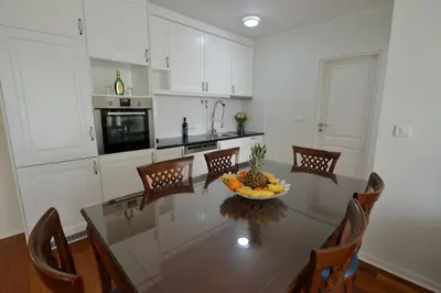 a kitchen with a table with a bowl of fruit on it at Vila Opera in Vrnjačka Banja