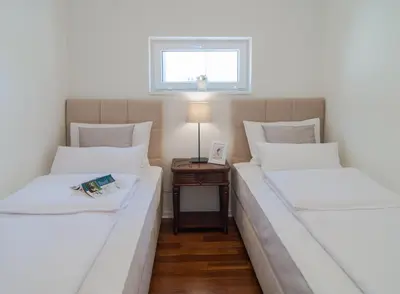 two twin beds in a room with a table at Vila Opera in Vrnjačka Banja