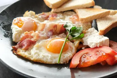 a plate of breakfast food with eggs and toast at Apartments Pavle in Kopaonik