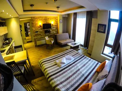 a bedroom with a bed and a living room at SM Apartments Kopaonik III in Kopaonik