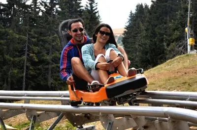 a man and a woman riding on a roller coaster at SM Apartments Kopaonik III in Kopaonik