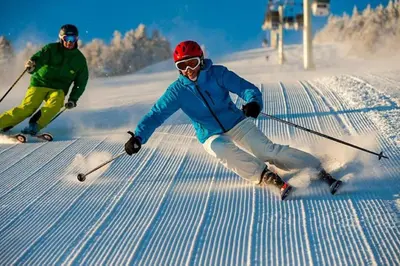 two people are skiing down a snow covered slope at SM Apartments Kopaonik III in Kopaonik