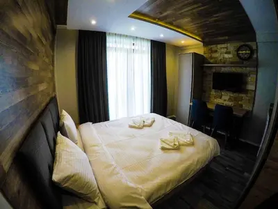 a hotel room with a large bed with a mirror at SM Apartments Kopaonik III in Kopaonik