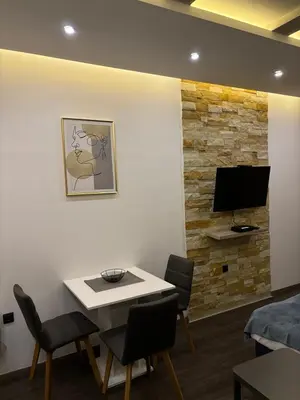 a room with a table and chairs and a tv on a wall at Ski & Spa K2 Milmari Resort Lux in Kopaonik