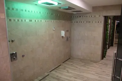 a walk in shower in a room with tiled walls at Ski & Spa K2 Milmari Resort Lux in Kopaonik