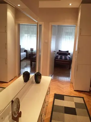 a living room with a table with two vases on it at Apartment Aloha in Vrnjačka Banja